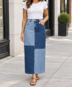 Woman wearing a patchwork denim midi skirt with a white tee in the city, shown from the neck down