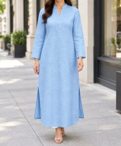 Woman in a sky blue linen shirt dress over slim trousers at a city cafe, shown from the neck down