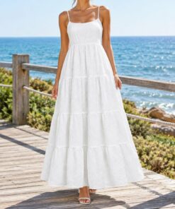 Woman in a white crinkle maxi sundress strolling on the beach at sunset, shown from the neck down